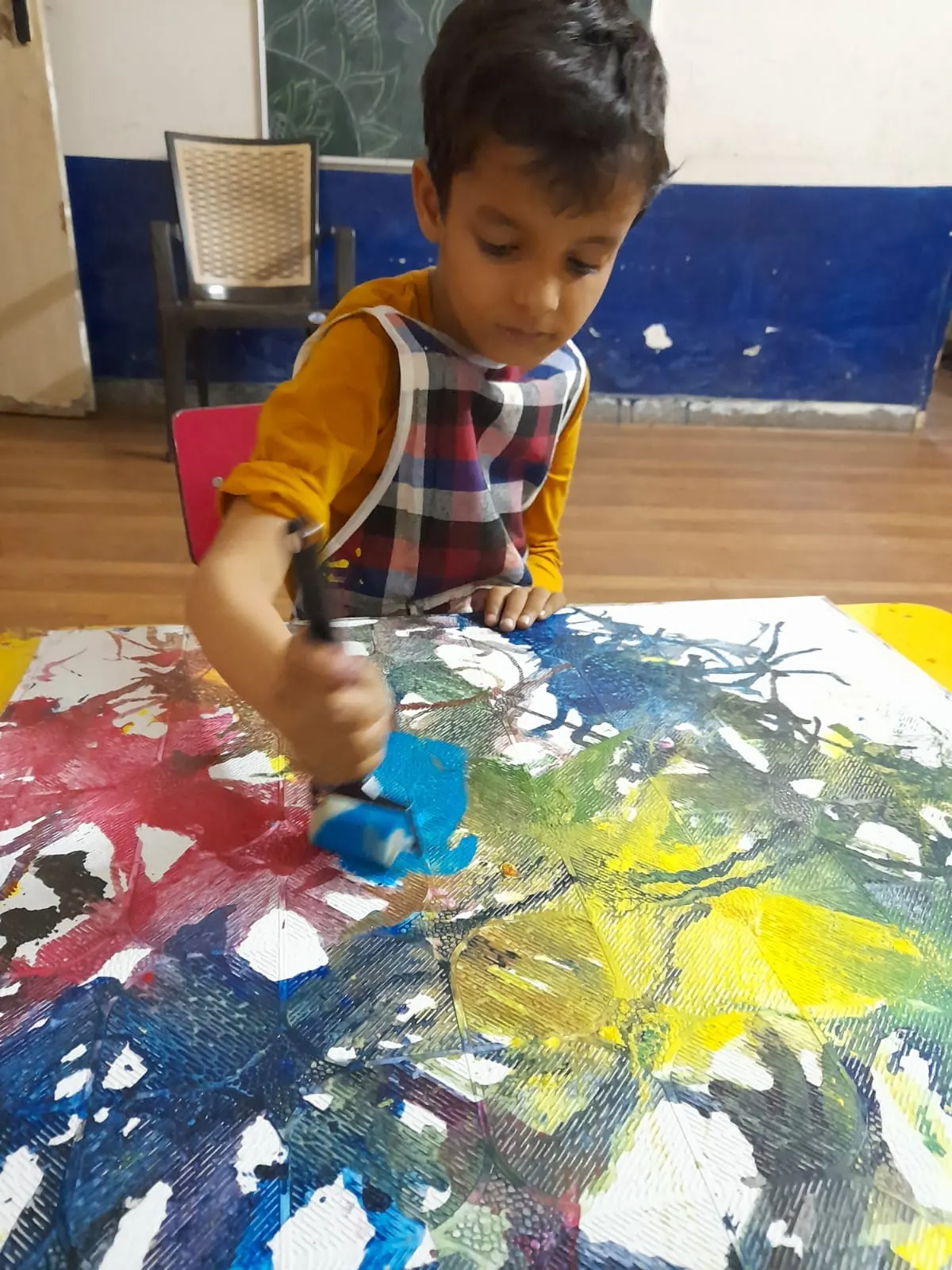 A student concentrating on a painting during an art session