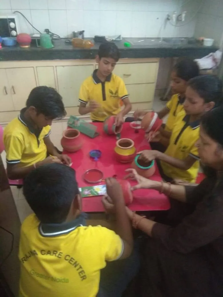 A student decorating a clay pot in a vocational session